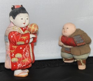 Two kimekomi dolls. The one on the right is older, probably 19th-century.  The one on the right is a typical mid-20th c. representation of a child playing. it is about 4 inches tall.