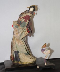 A 12-inch-tall modern doll of washi paper, and beside it a tiny paper doll depicting awa odori, the rice-planting dance.