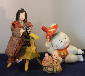 Three dolls in various media showing children playing.  The small baby is 2 inches tall (exclusive of toy).  The boy on a horse is probably 19th century; the boy with a mask dates from the past 30 years or so.