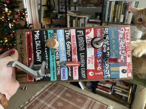 crafted hat rack with painted book bindings and attached objects