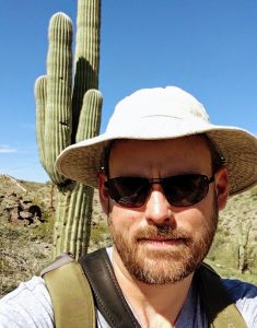 Dr. Douglas in front of a Saguaro cactus in Arizona