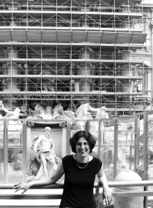 black and white photo of Professor Jennifer A. Rea standing in front of white marble statues and scaffolding